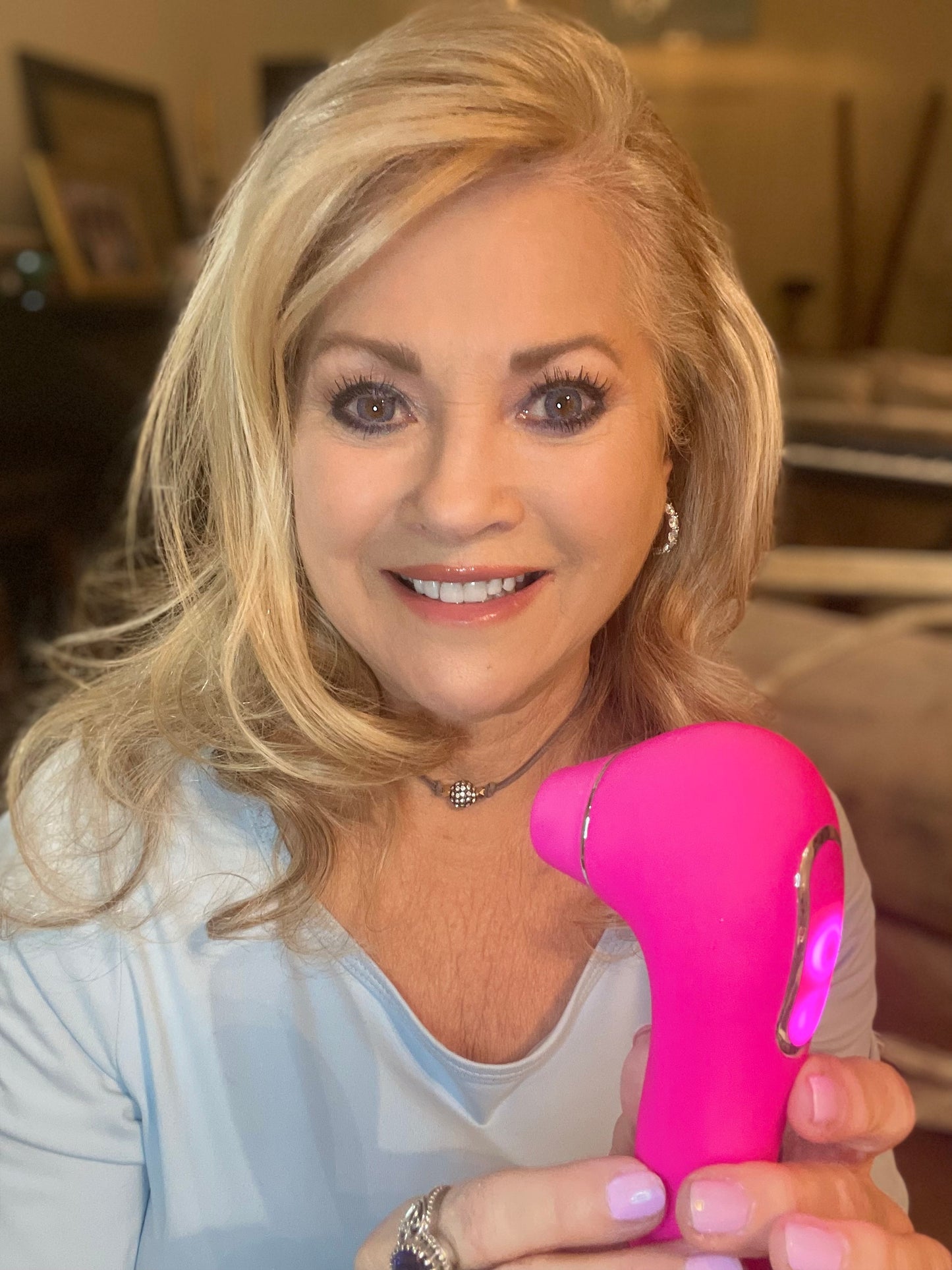 Woman holding a pink intimate pleasure device from VIVA, featuring a sleek design and LED light.