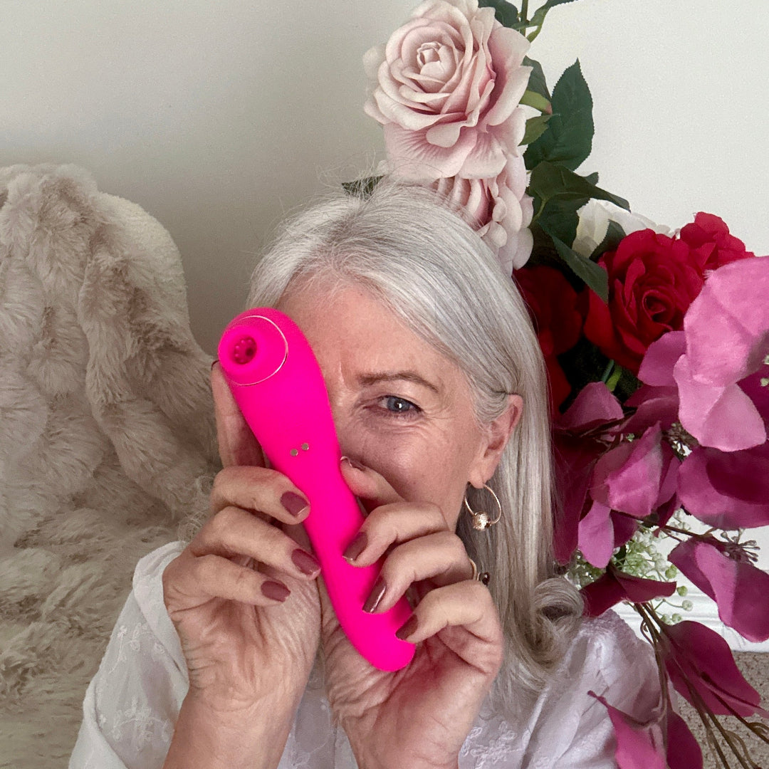 Pink clitoral stimulator from Mr. & Mrs. Vibe Couples Intimacy Bundle with floral background